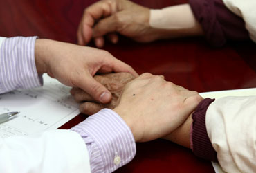 일산자생한방병원 자생치료의 특징-환자 손을 잡아 건강상태를 체크 하고 있는 의사의 모습